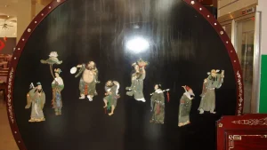 Eight Immortals decorations mounted on a circular dark display