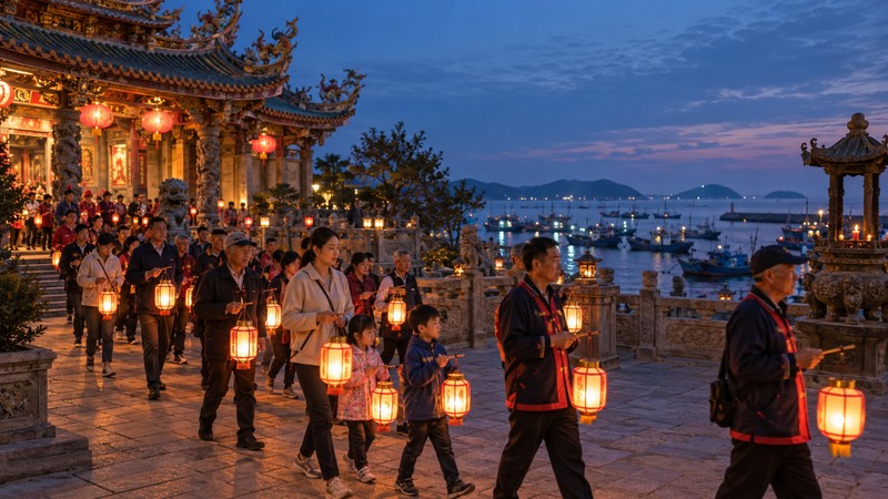 Families and fisherfolk carrying lanterns through a coastal temple courtyard at blue hour